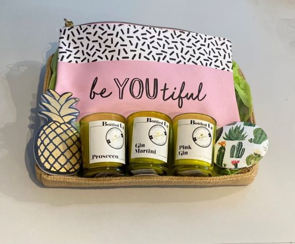 Jute storage tray gift basket containing a sass and Belle beYOUtiful make up bag, 3 soy wax cocktail themed votive candles in recycled glass holders, a cactus handbag mirror and a novelty pineapple shaped nail file