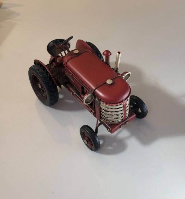 Miniature replica of a classic red tractor.
