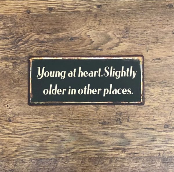 Young at heart. Slightly older in other places metal sign