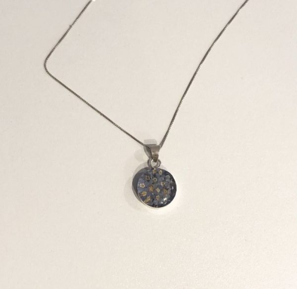circle shaped silver pendant necklace filled with forget me not flowers