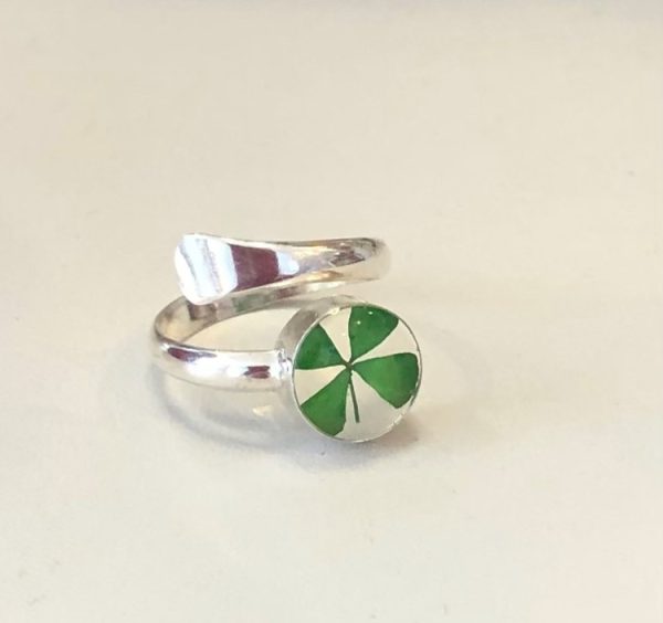 Lucky four leafed clover encased in resin and mounted on a hand crafted sterling silver band