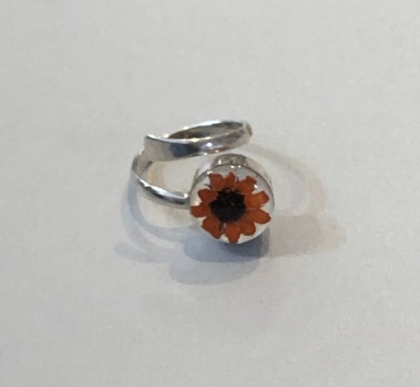 Adjustable silver ring with a real sunflower encased in resin and mounted on a hand crafted silver band