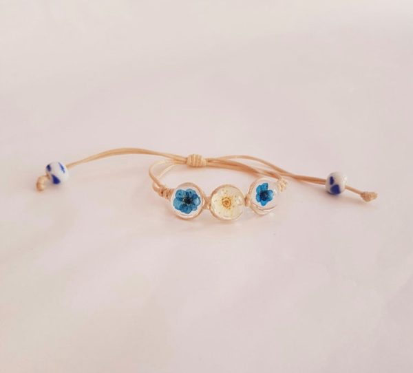 Cord bracelet with real blue and white flower charms