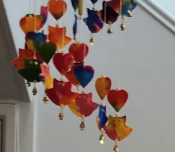 multicoloured mobile made up of owls, hearts and tiny bells