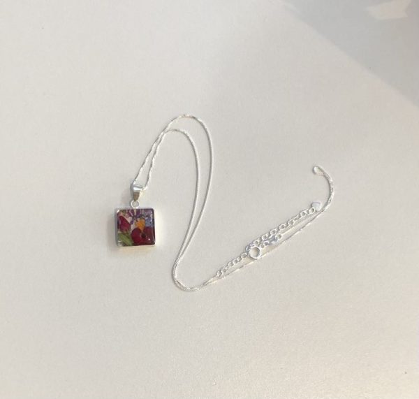 Square shaped silver pendant filled with a mix of tiny real flowers encased in resin
