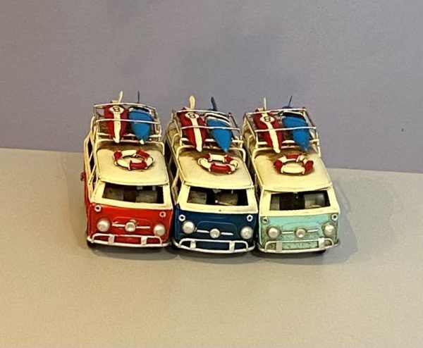 Small tin replicas of a classic VW campervan in light blue, red and dark blue.