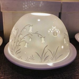 Dome tea light holder with a ladybird and flower design etched into its dome to create a stunning effect when it is lit from within
